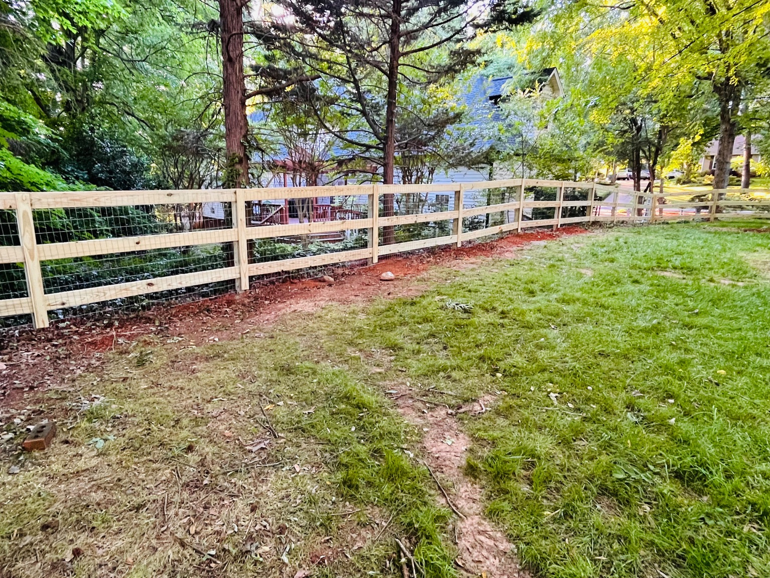 Wood and wire fence enclosing a yard